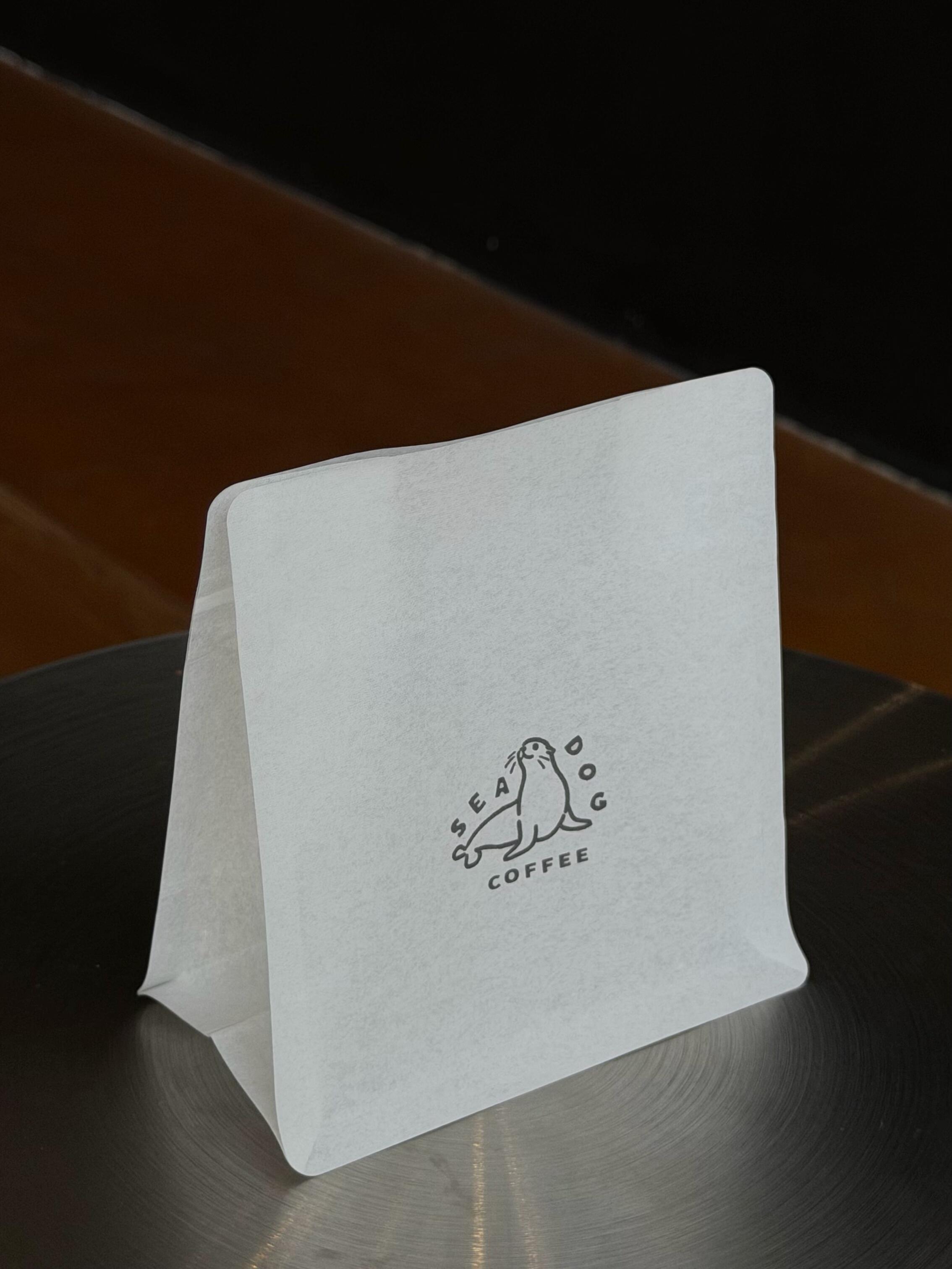 Minimal white pouch with a small coffee logo